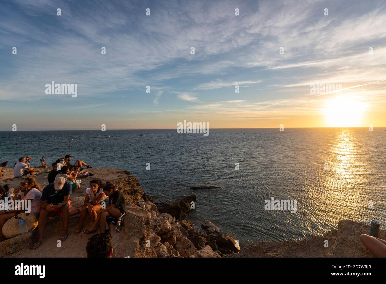 Gente mirando la puesta de sol en Cabo Trafalgar, provincia de Cádiz, Andalucía, España Foto de stock