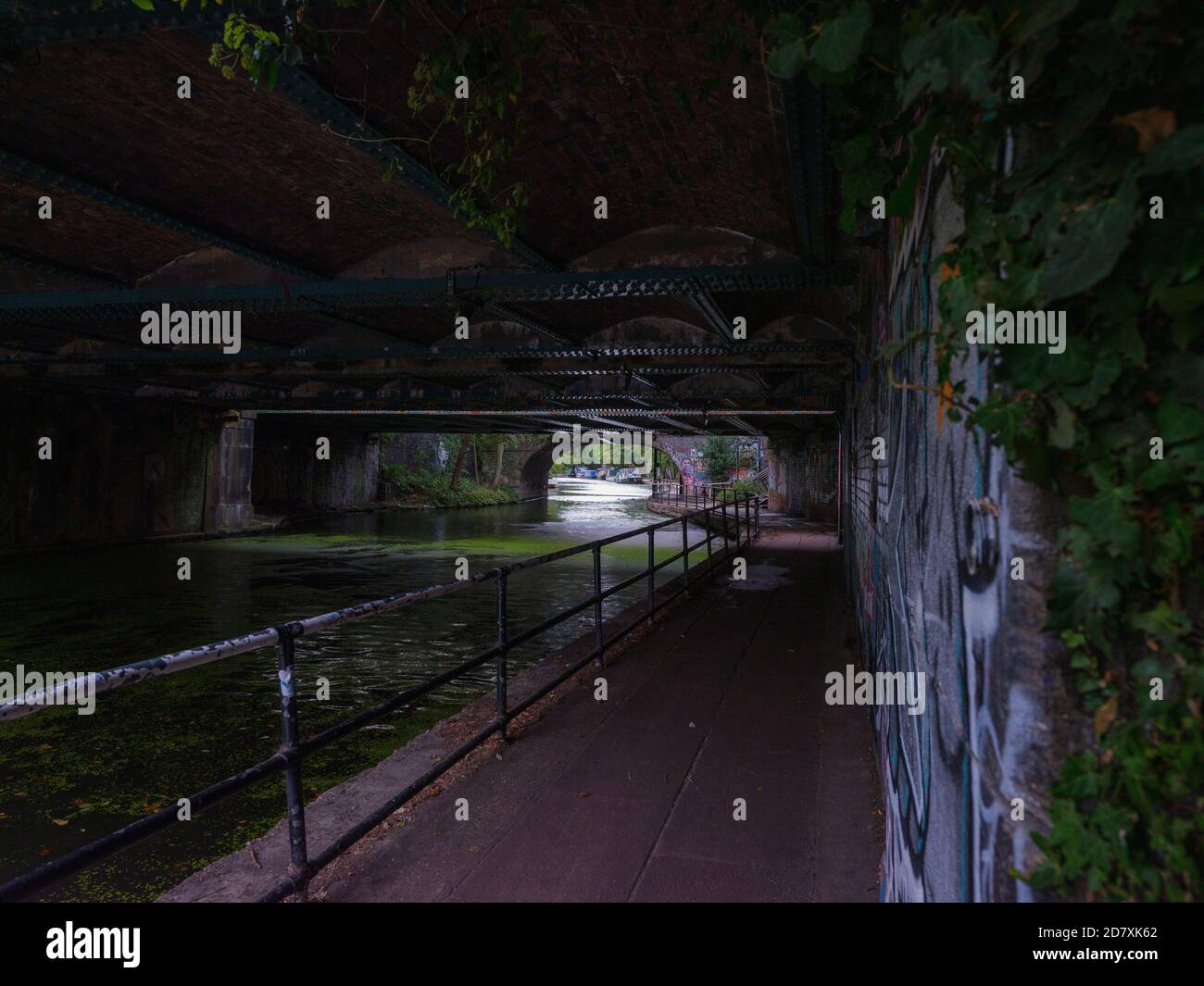 Regents Canal camino de remolque cerca de Camden Market en Gloucester Avenue Debajo de los puentes ferroviarios victorianos que transportan trenes desde Euston Estación Foto de stock