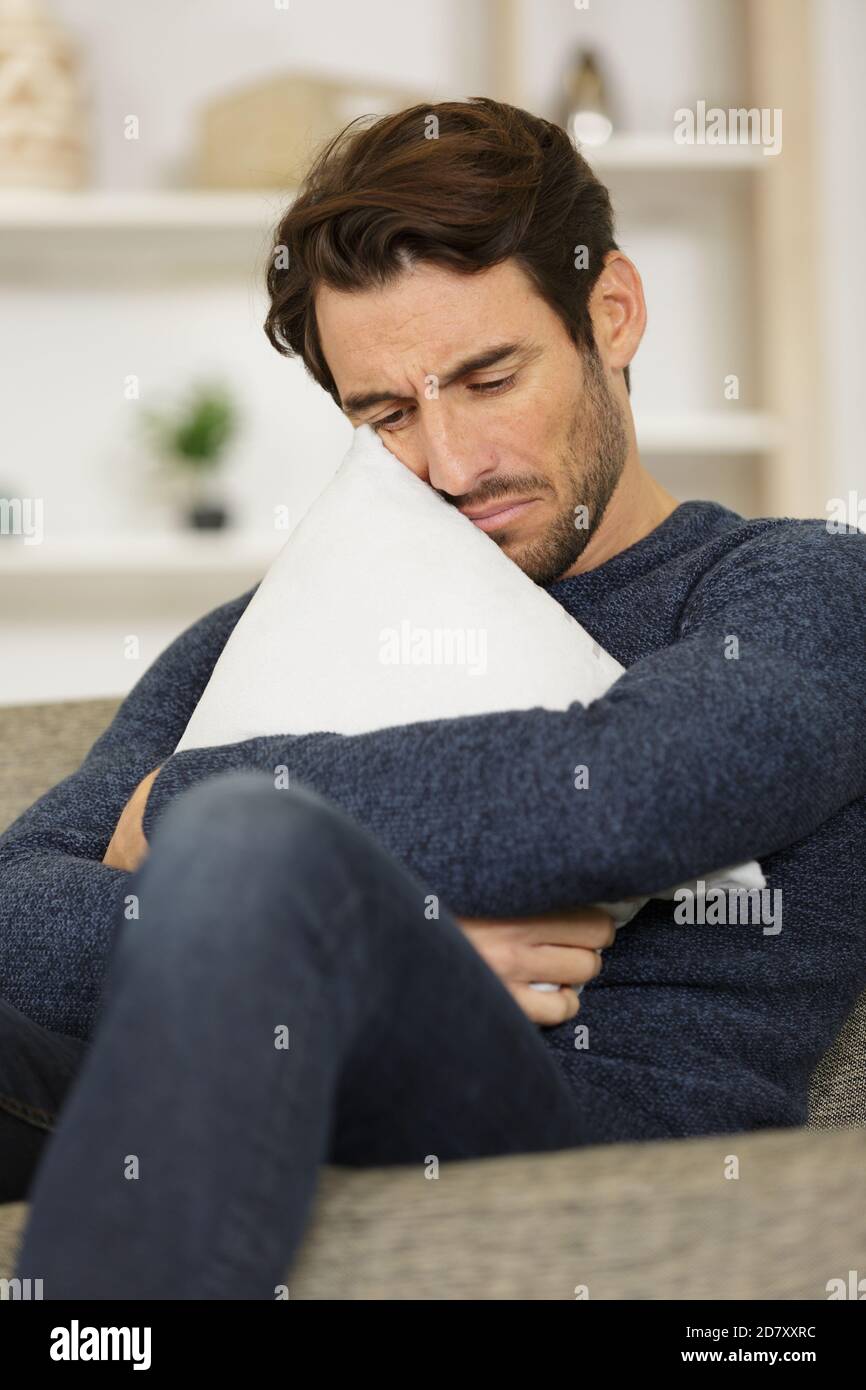 un hombre triste abrazando una almohada Fotografía de stock - Alamy