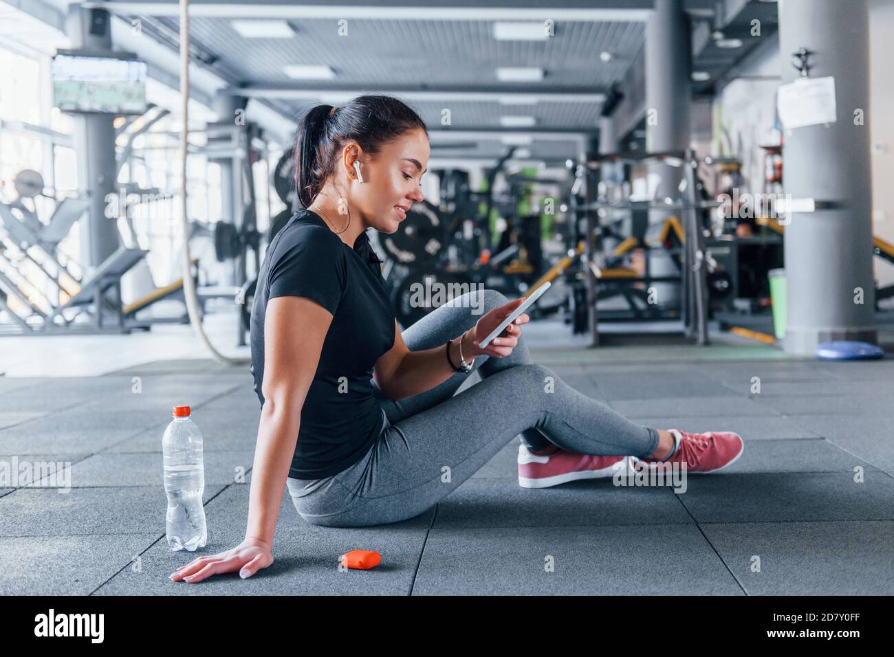 Niña en ropa deportiva tomando un descanso con comida y hay agua en el  gimnasio durante el día Fotografía de stock - Alamy