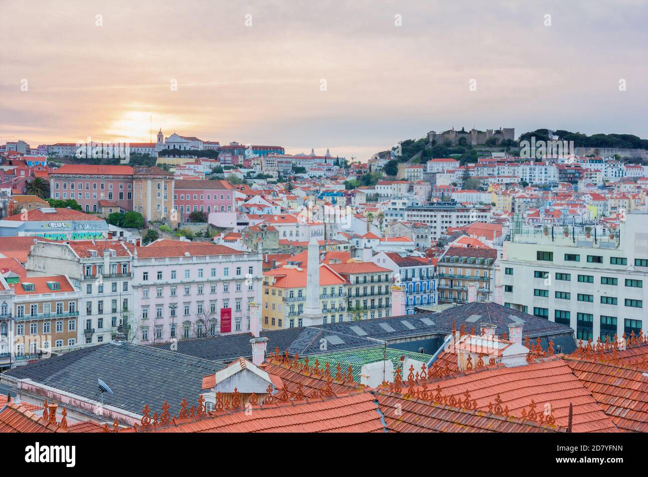 Vista de hermosas y coloridas casas desde arriba durante el amanecer con el cielo naranja y rosa en Lisboa, Portugal. Foto de stock