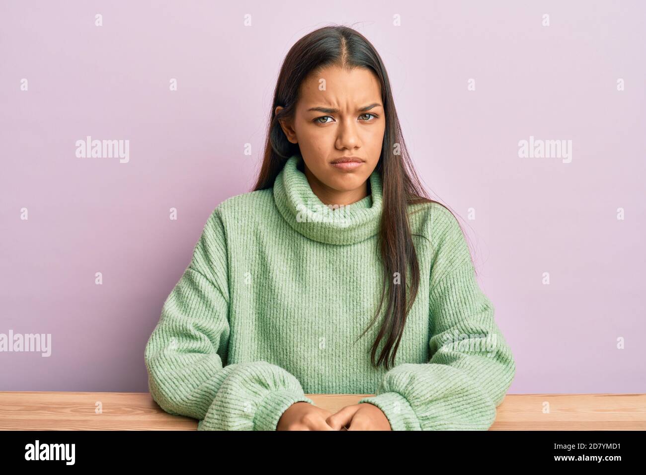 Hermosa mujer hispana con ropa informal sentada en la mesa escéptica y  nerviosa, desenfadada por problemas. Persona negativa Fotografía de stock -  Alamy