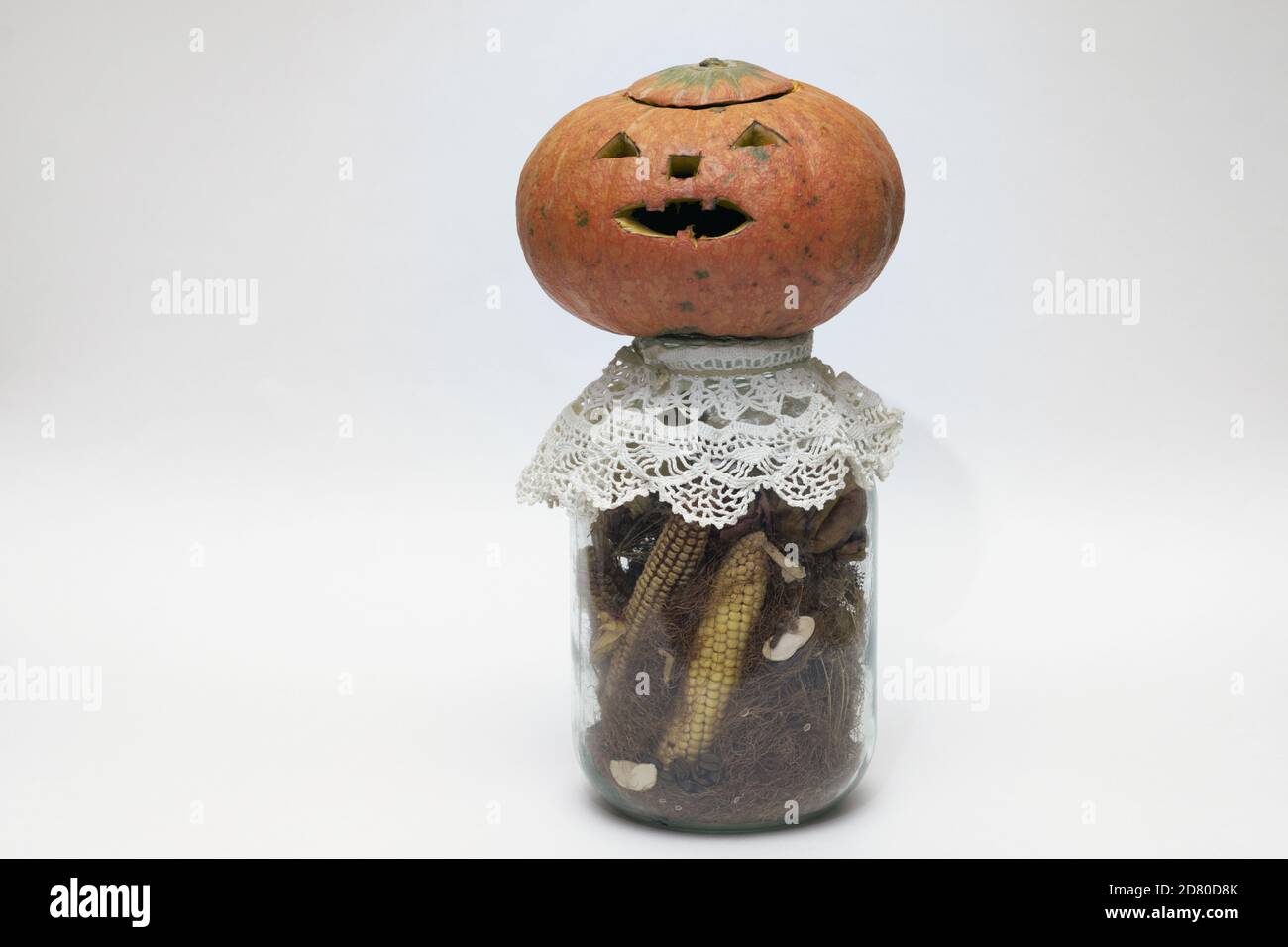 calabaza de halloween en botella con maíz seco. cara simbólica tallada en calabaza vacía sin linterna en el interior Foto de stock