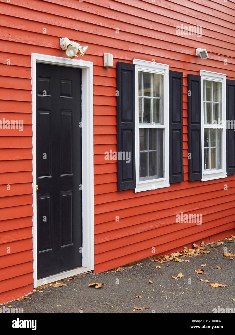 La casa tiene paredes rojas con puertas y persianas negras Fotografía de  stock - Alamy