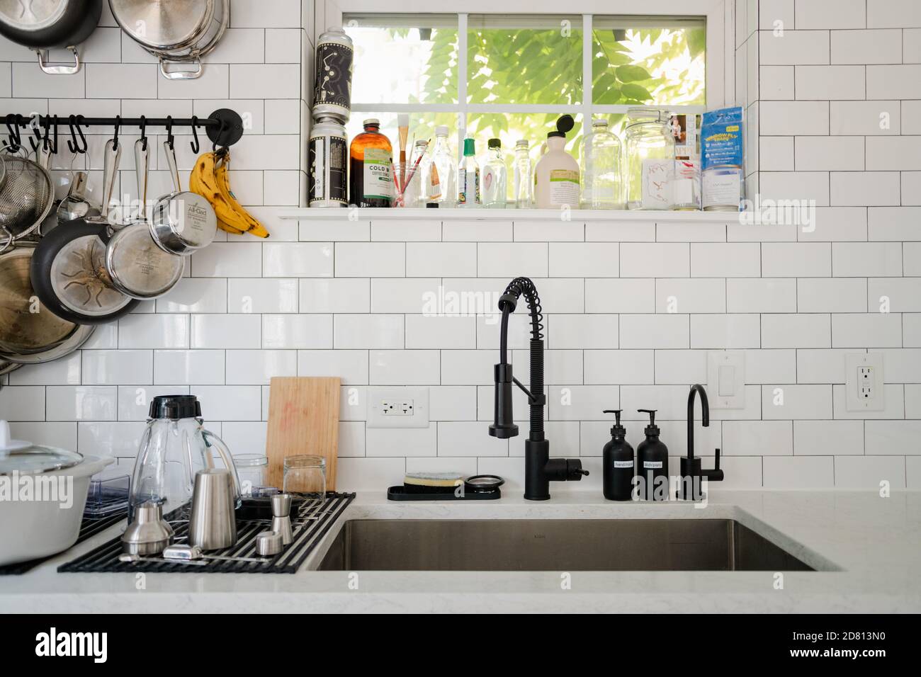 Fregadero de la cocina con platos en el estante seco y cacerolas colgantes  Fotografía de stock - Alamy