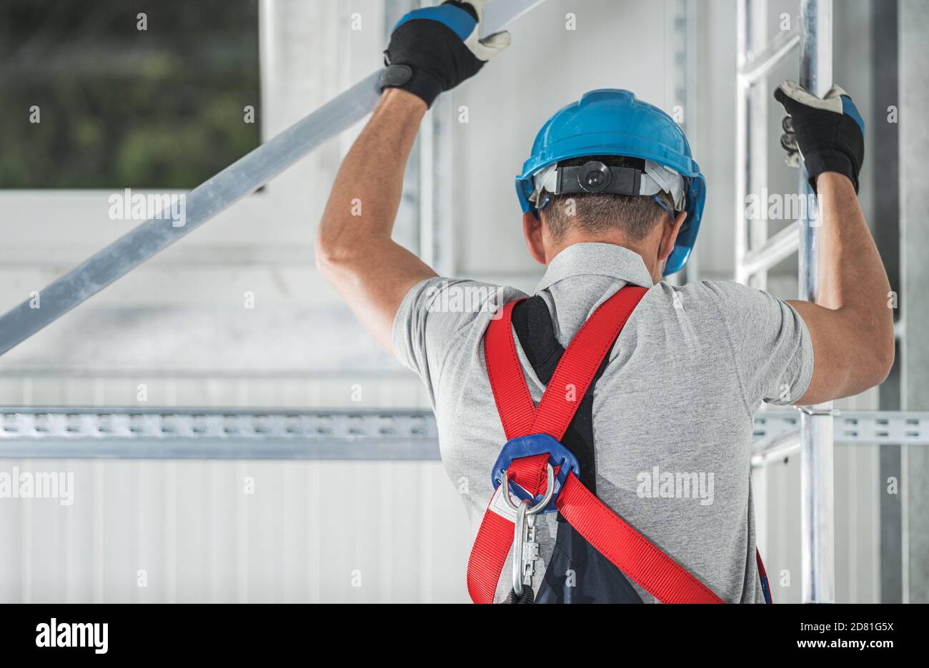 Trabajador de la construcción que usa arnés de seguridad Escalada sobre  andamiaje de aluminio en la Zona de Construcción Fotografía de stock - Alamy