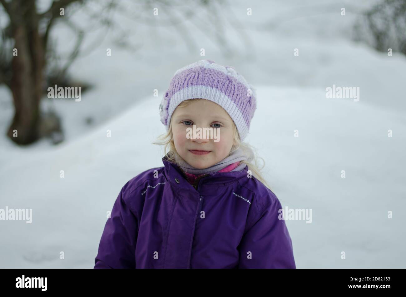 retrato de niña pequeña y encantadora en el fondo de invierno Foto de stock