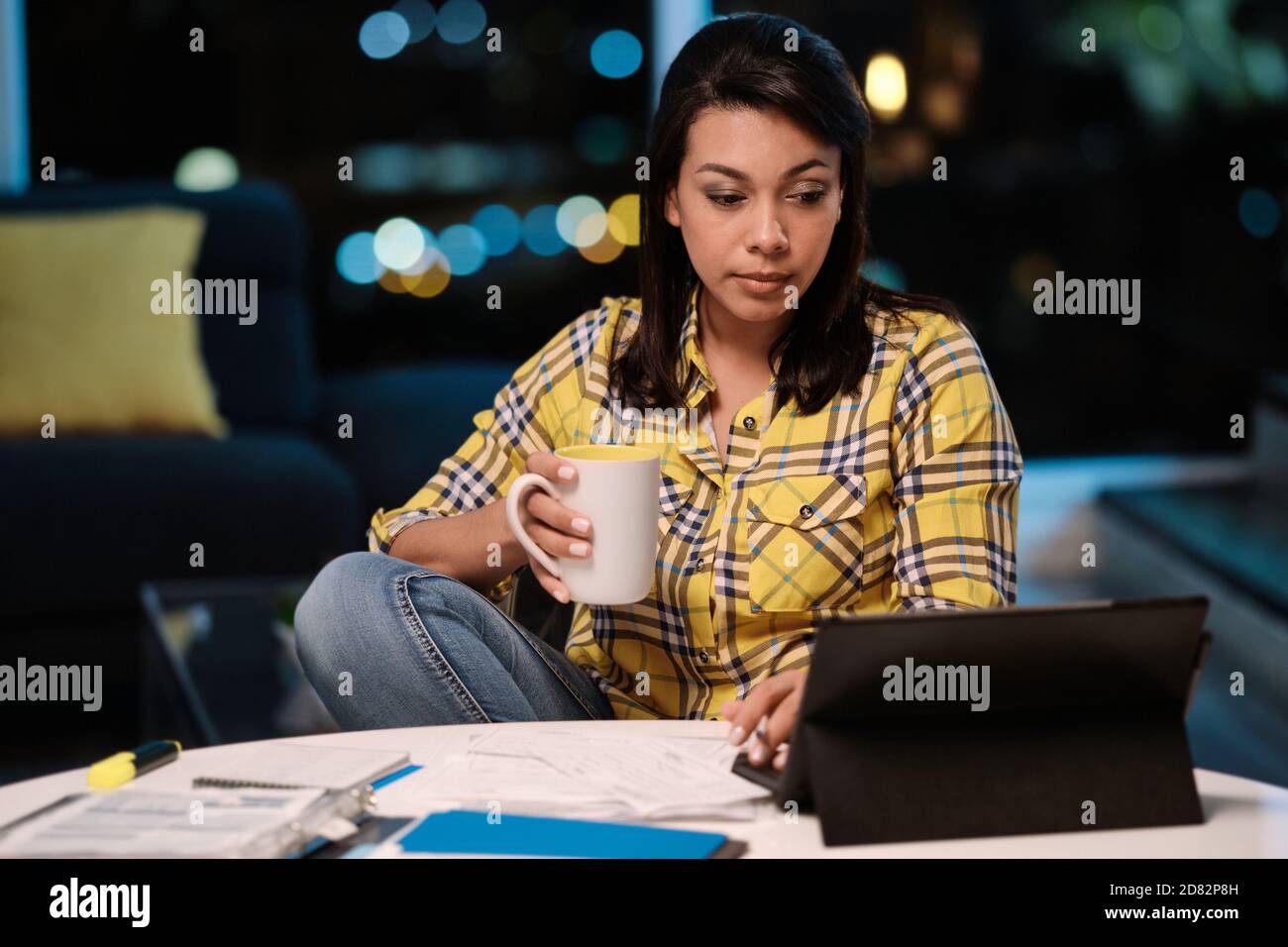 Mujer latinoamericana trabajando desde casa por la noche Foto de stock