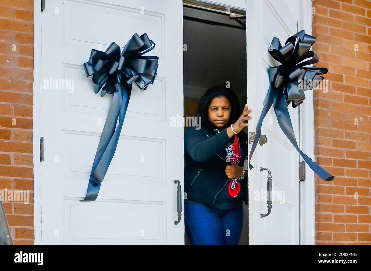 Una mujer sale del Museo del Antiguo Palacio de Justicia donde las cintas negras cuelgan después de la muerte del autor local Harper Lee, 19 de febrero de 2016, en Monroeville, Alabama. Foto de stock