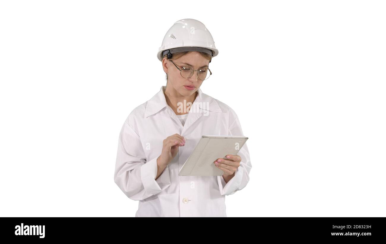 Joven ingeniera pensativa trabajando con su tableta en wh Foto de stock