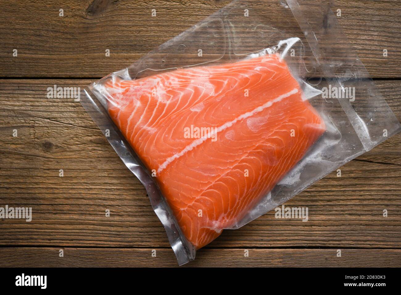 Filete de salmón crudo fresco sobre fondo de madera / Salmón filete  empaquetado en paquete de vacío de plástico en embalaje vender en  supermercado Fotografía de stock - Alamy