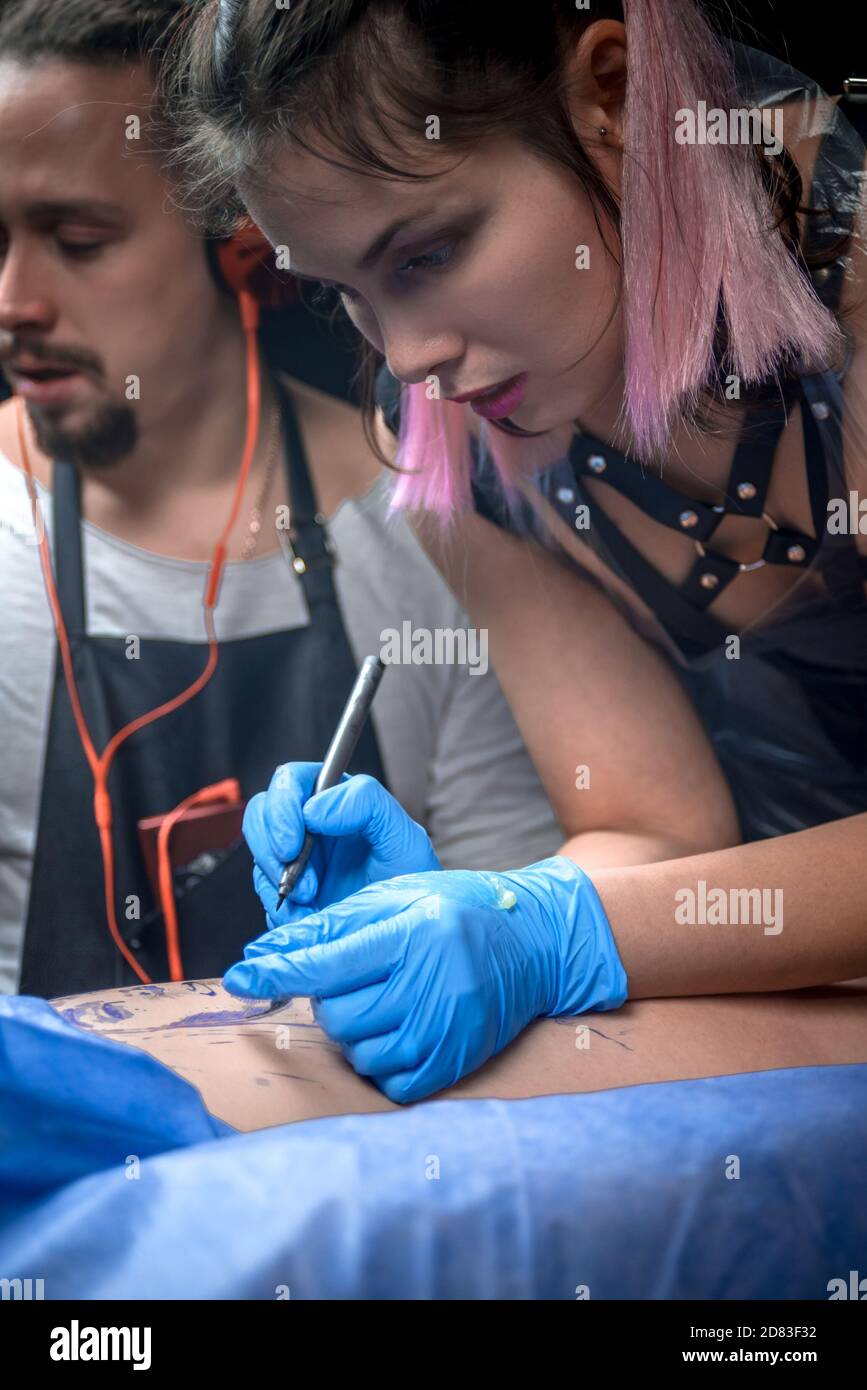 Tatuaje profesional artista trabajando en máquina de tatuaje profesional dispositivo en estudio de tatuaje Foto de stock