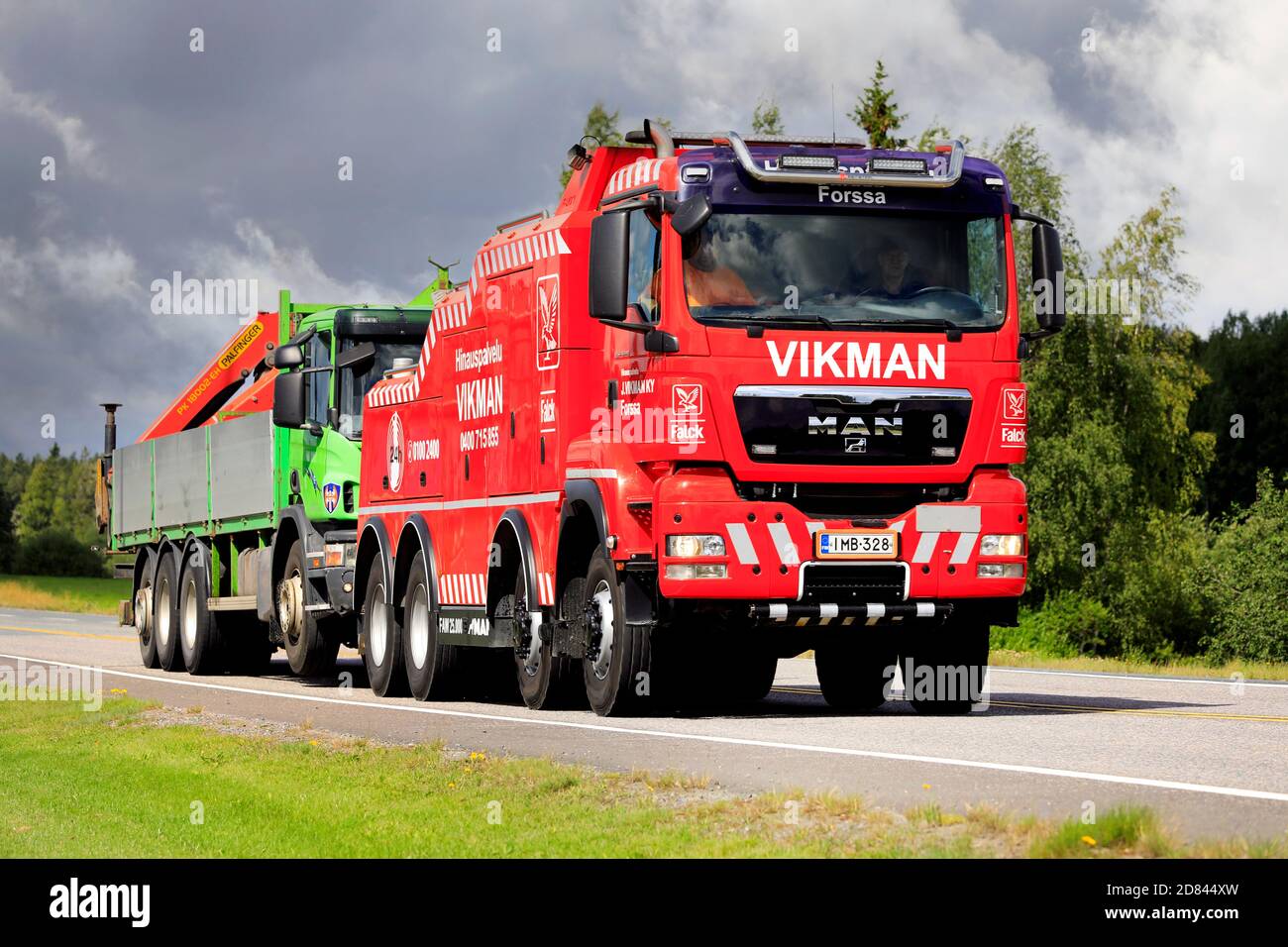 Camión grúa siendo remolcado por MAN TGS 41.440 camión de servicio pesado de Hinauspalvelu J Vikman Ky a lo largo de la carretera 2. Forssa, Finlandia. 7 de agosto de 2020. Foto de stock