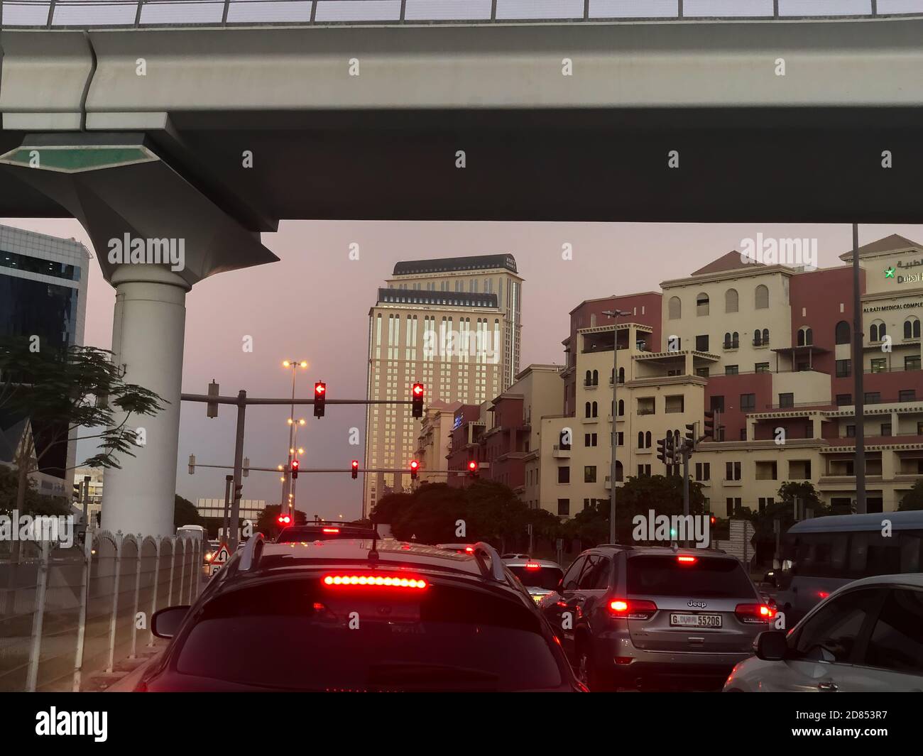 Dubai, Emiratos Árabes Unidos - 15 de octubre de 2020: Los vehículos se detuvieron en un semáforo rojo, en un cruce muy concurrido en Dubai al atardecer. Foto de stock