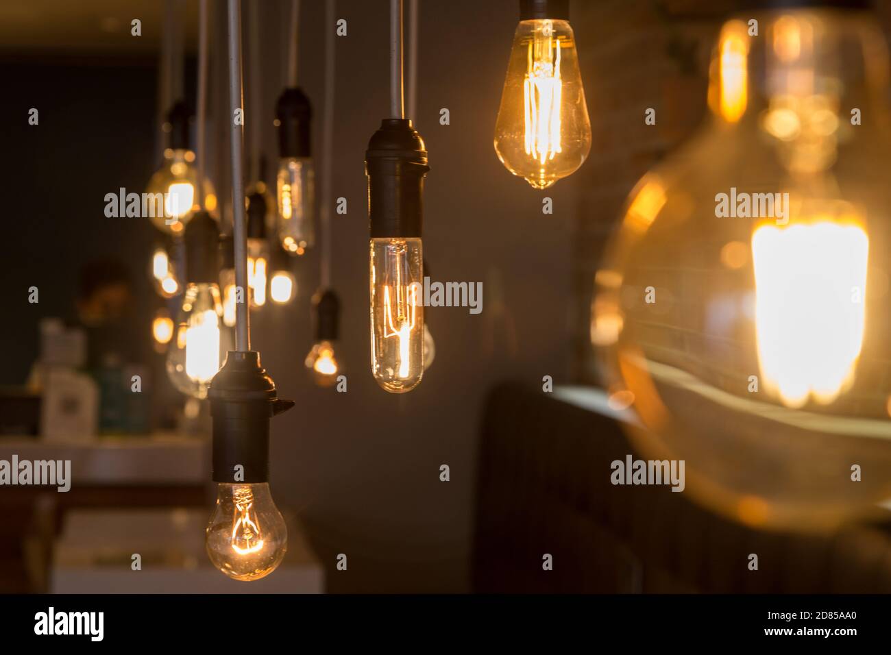 primer plano con focos de luz amarilla colgada con alambre, decoración  interior moderna, con fondo oscuro Fotografía de stock - Alamy