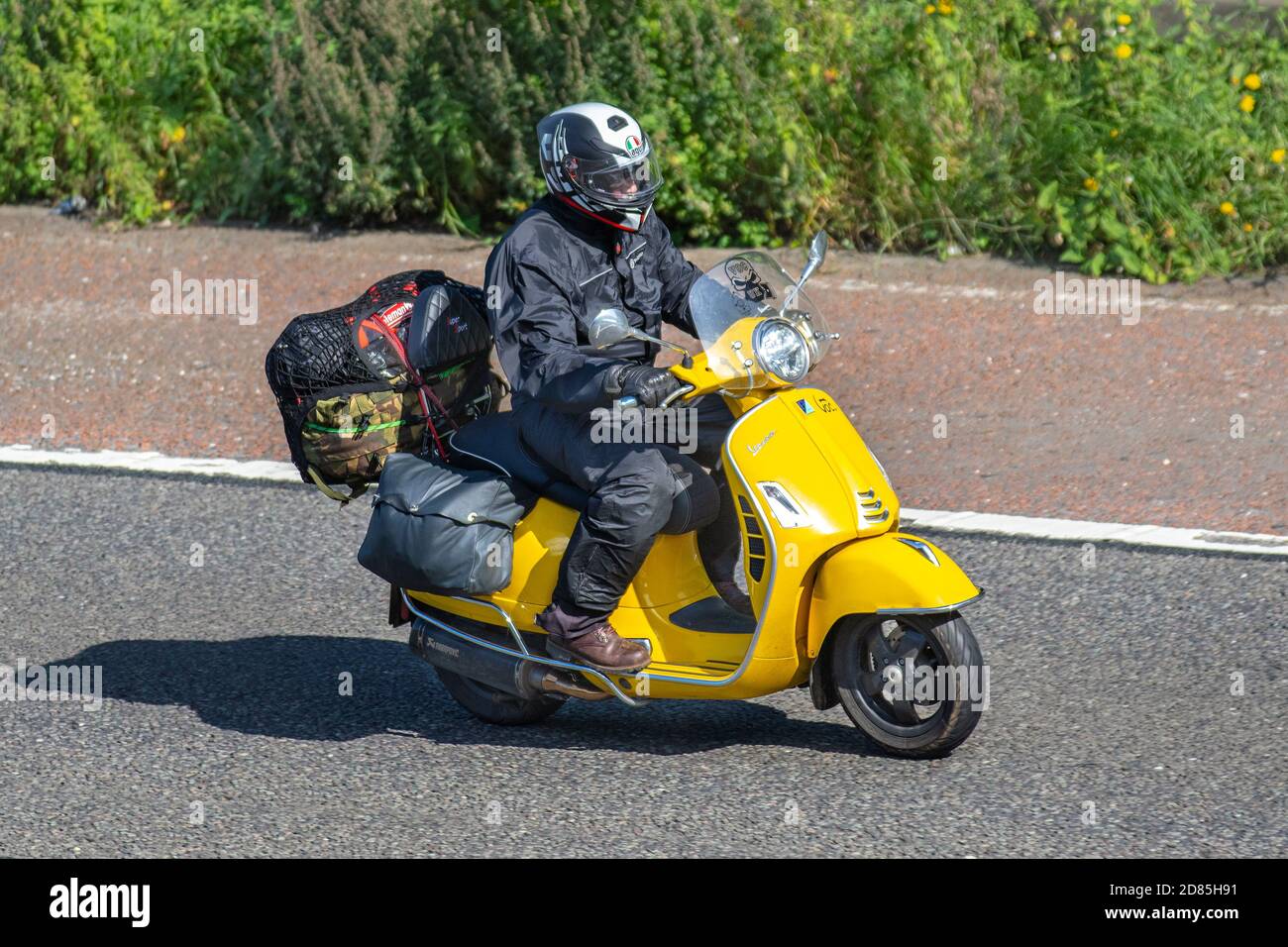 Vespa Scooter jinete amarillo; dos ruedas de transporte, motocicletas, vehículos, carreteras, motos, motociclistas motoring en Chorley, Reino Unido Foto de stock