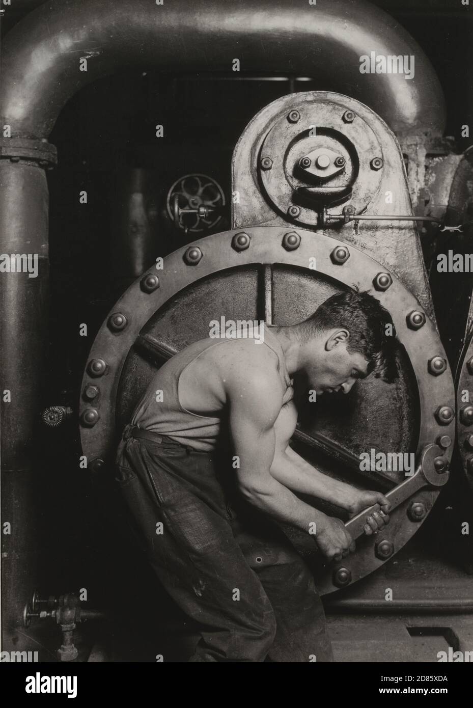 Foto vintage Lewis W. Hine - Steamfitter 1920 - un hombre trabajador duro con una herramienta grande. Foto de stock