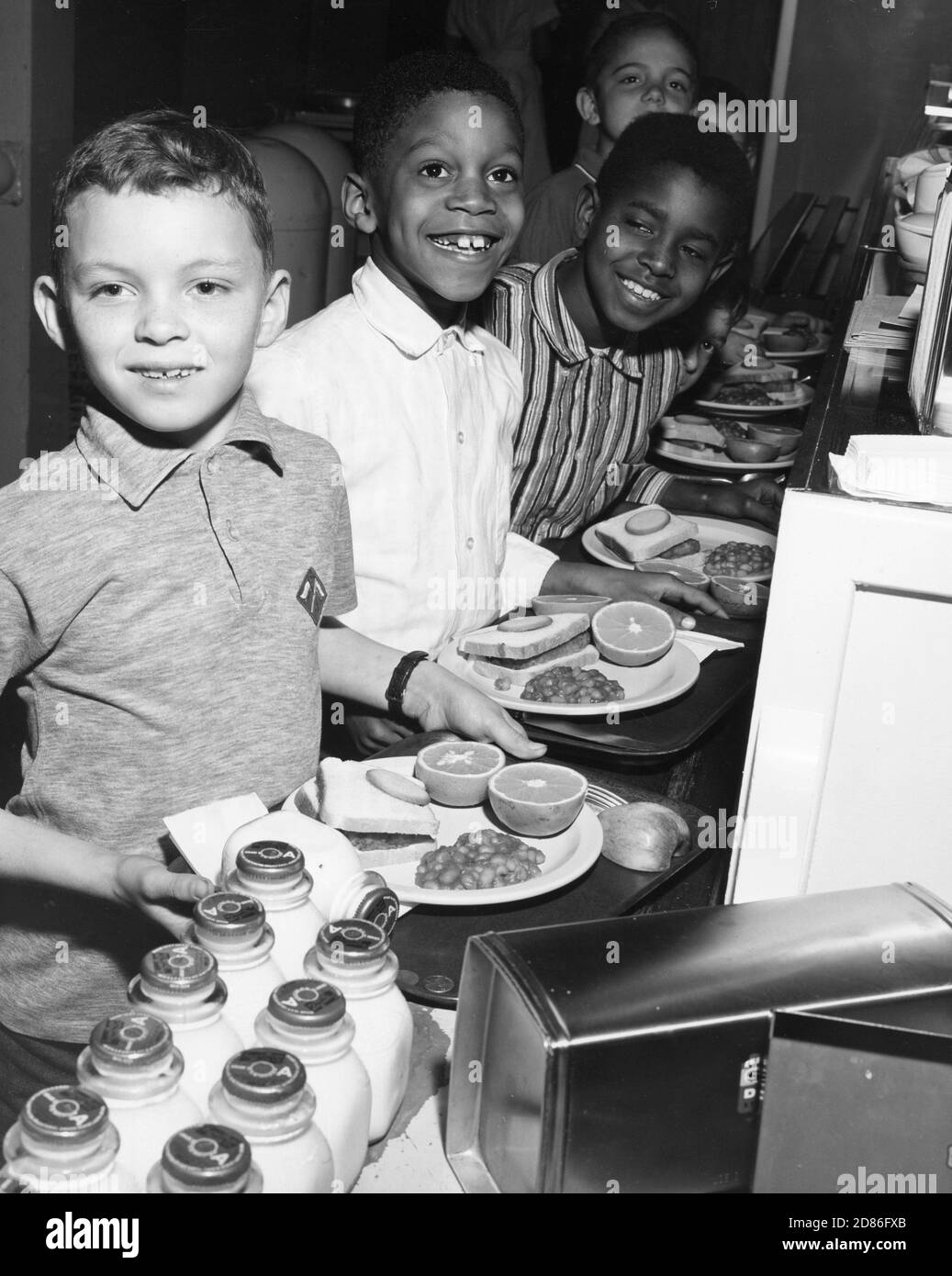 Estudiantes en línea en la Escuela Primaria Finzer con bandejas de almuerzo que contienen una comida bien balanceada proporcionada a través del Programa Nacional de almuerzo Escolar, Louisville, KY, 1967. (Foto del Departamento de Agricultura de los Estados Unidos/Imágenes de la Vintage de la RBM) Foto de stock