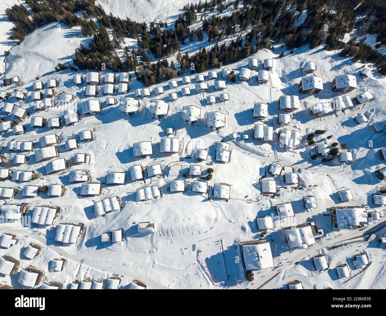 Vista aérea de los tejados cubiertos de nieve sobre los chalés tradicionales en el pueblo de los alpes suizos. Foto de stock
