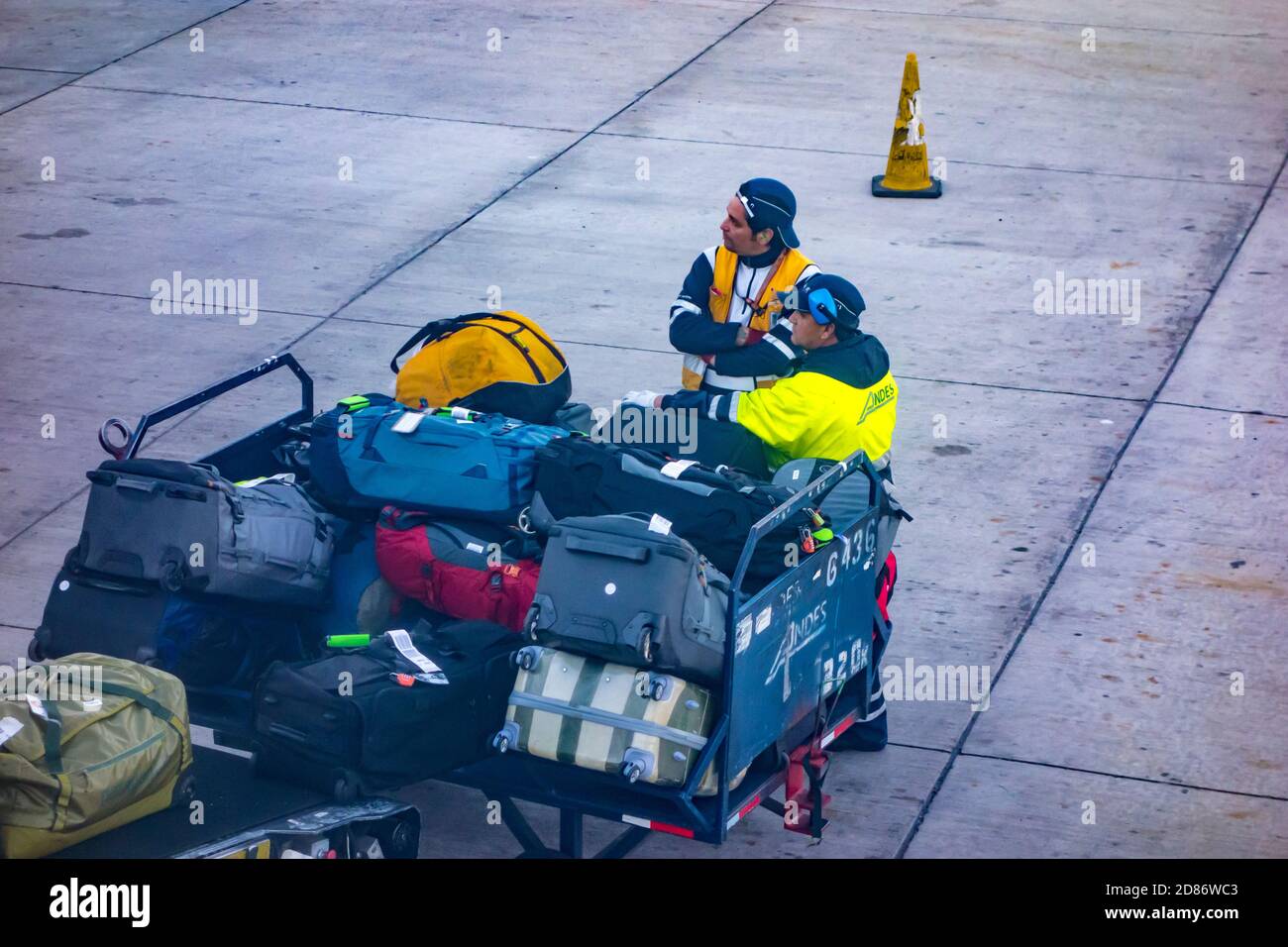 Carritos de equipaje y manejadores de equipaje en el Aeropuerto Internacional Arturo Merino Benítez en Santiago, Chile Foto de stock