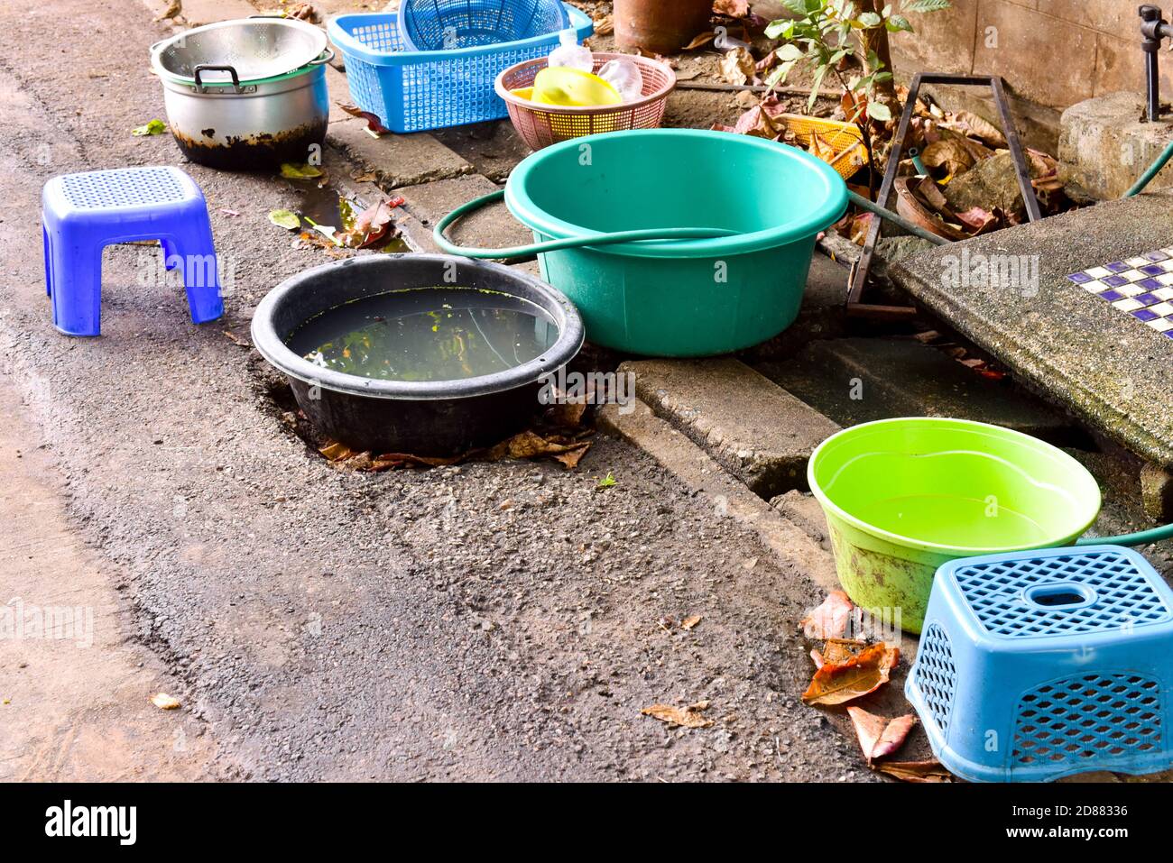 La falta de agua corriente hace que la gente lave los platos en las calles, Chiang Mai, Tailandia Foto de stock