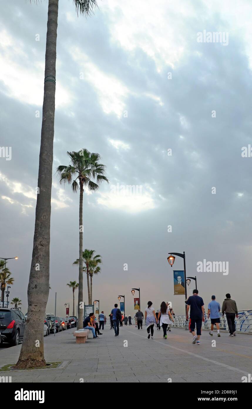 Los cielos nublados permanecen sobre la cornisa costera mediterránea en Beirut, Líbano, mientras la gente hace ejercicio y pasea por el paseo marítimo el 26 de abril de 2016. Foto de stock