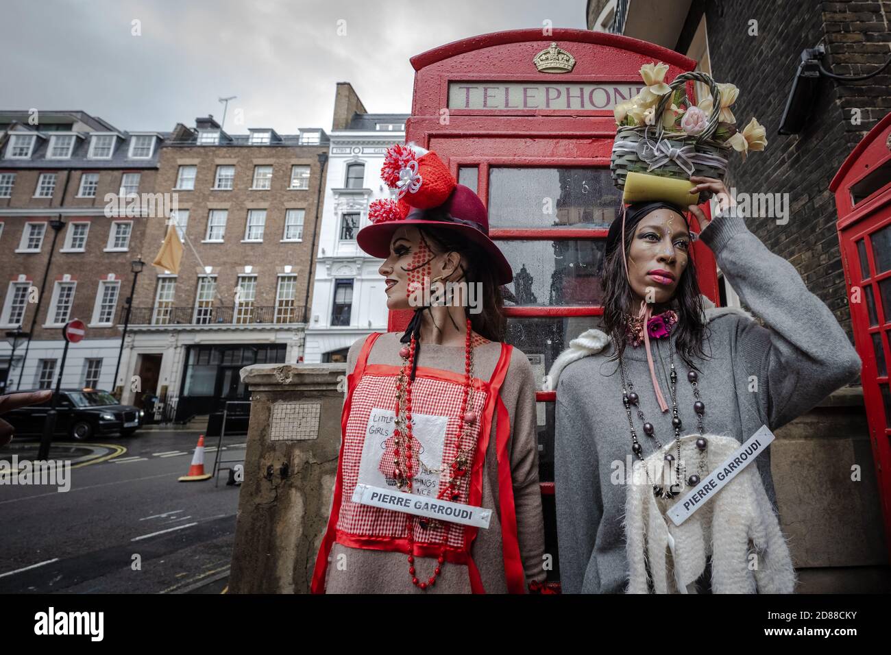 Los modelos participan en un colorido espectáculo de moda callejera cerca de Savile Row para el diseñador Pierre Garroudi. Londres, Reino Unido. Foto de stock