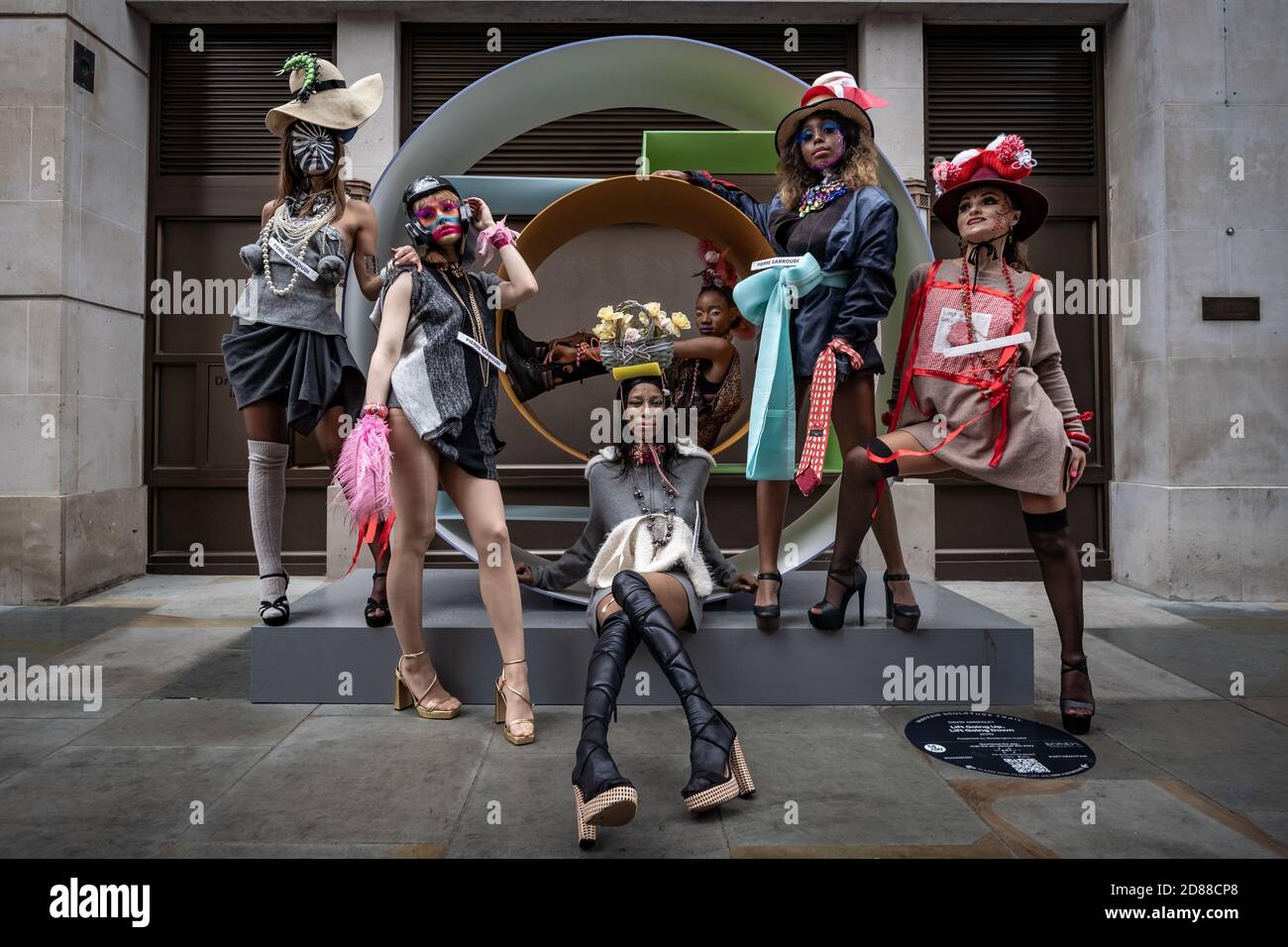 Los modelos participan en un colorido espectáculo de moda callejera cerca de Savile Row para el diseñador Pierre Garroudi. Londres, Reino Unido. Foto de stock