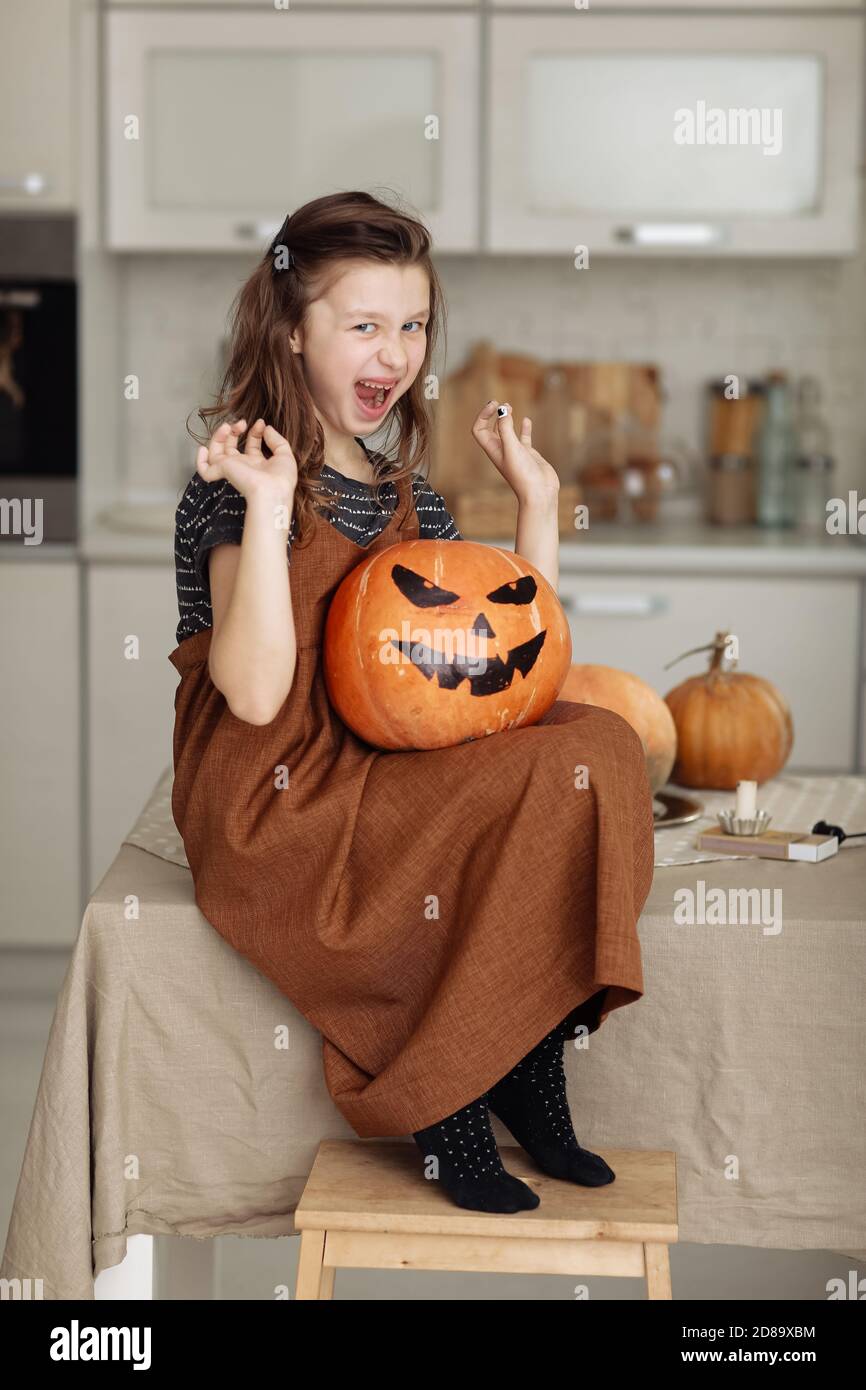 Feliz Halloween. Cute Little Girl en disfraz de bruja con calabaza tallado.  Familia feliz preparando para Halloween Fotografía de stock - Alamy