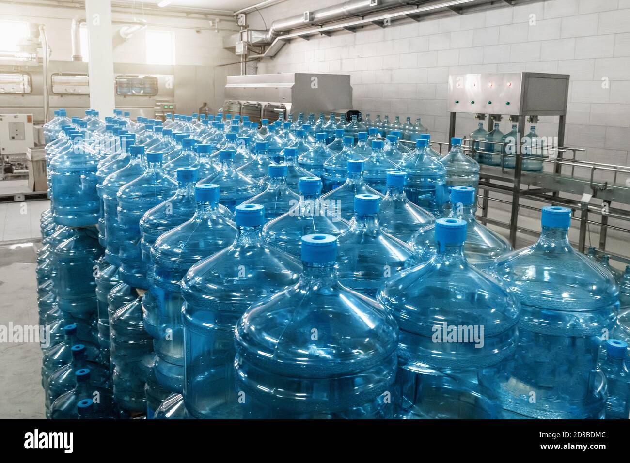 Galones o botellas de plástico de agua potable purificada en la fábrica de producción de agua. Foto de stock