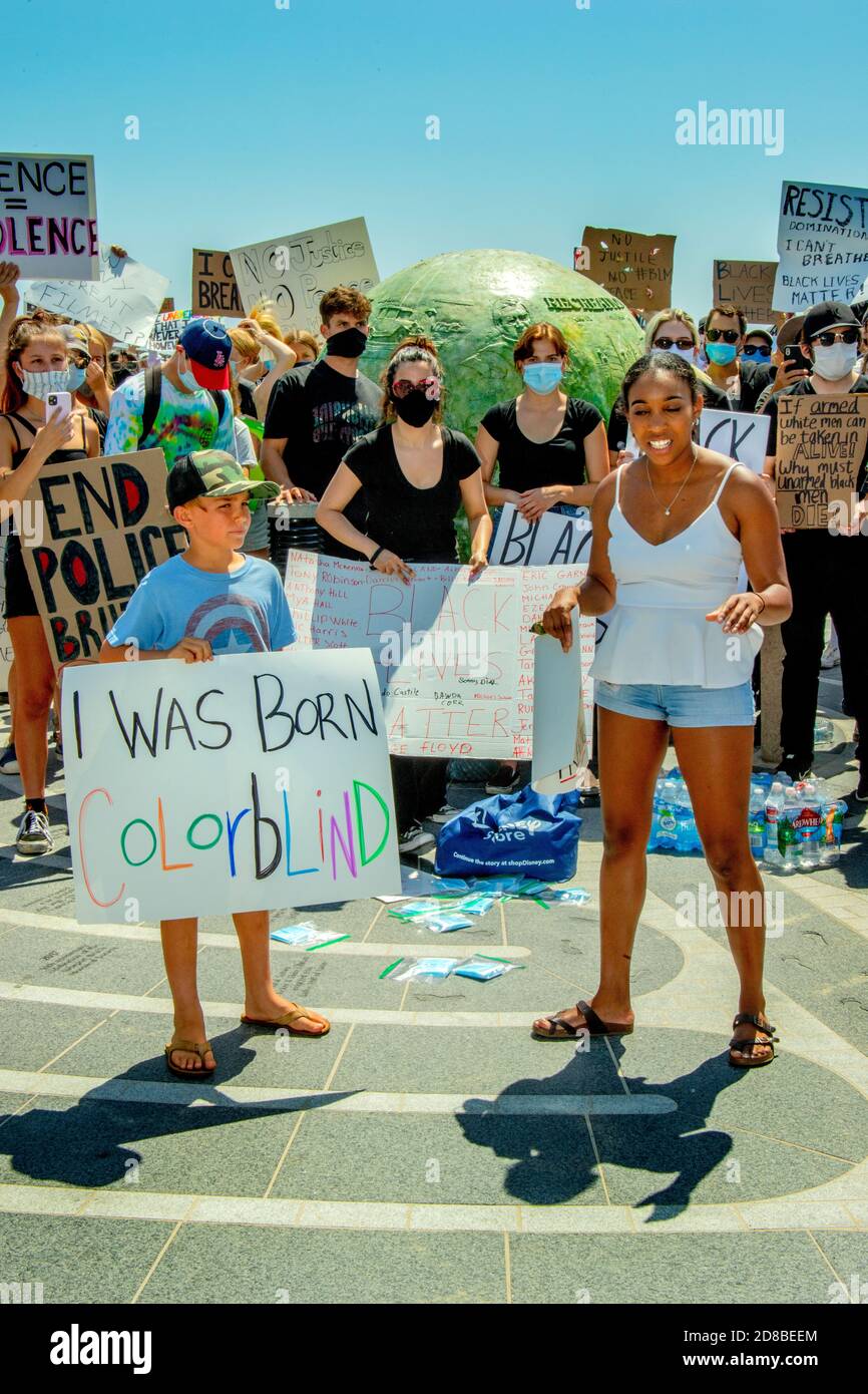 Usando máscaras debido al coronavirus, una demostración de Black Lives Matter lleva signos en Newport Beach, CA. Foto de stock