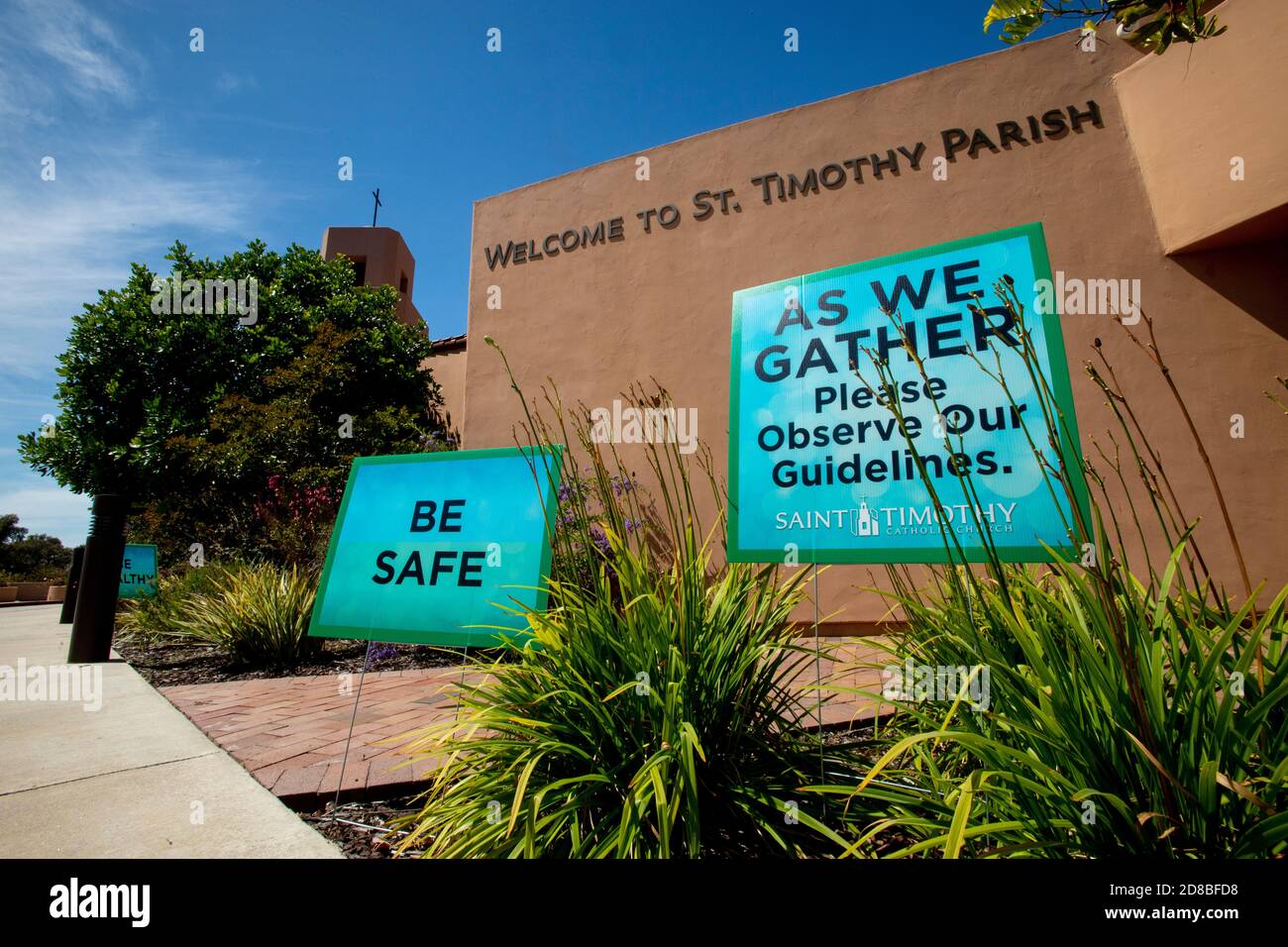 Las señales en una iglesia católica del sur de California dan la bienvenida a los feligreses que llegan mientras les advierten que observen las medidas de seguridad durante el coronavirus pand Foto de stock