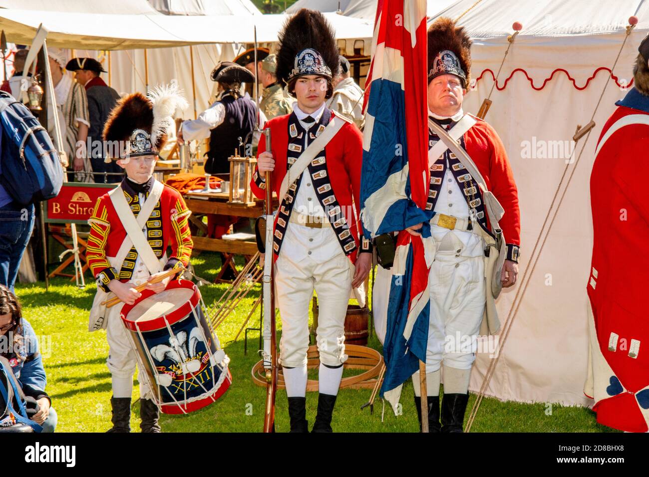 Los soldados del Ejército Británico Redcoat y un niño baterista son retratados por actores en una reconstrucción de la Guerra Revolucionaria Americana en Huntington Beach, CA. Foto de stock