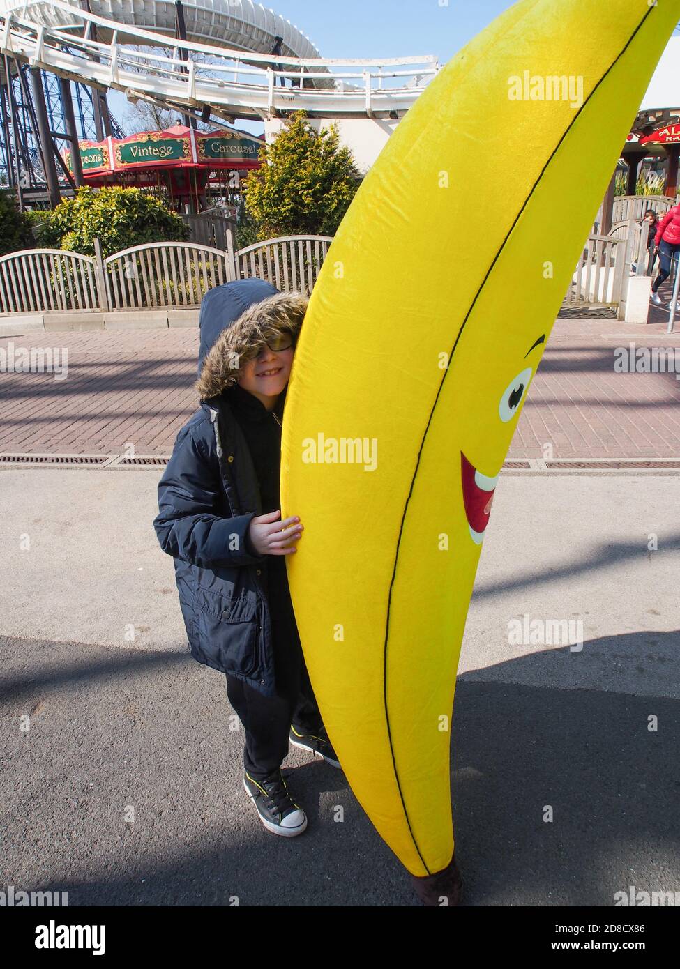 Un poco con un gran plátano inflable que era ganó en una feria Foto de stock