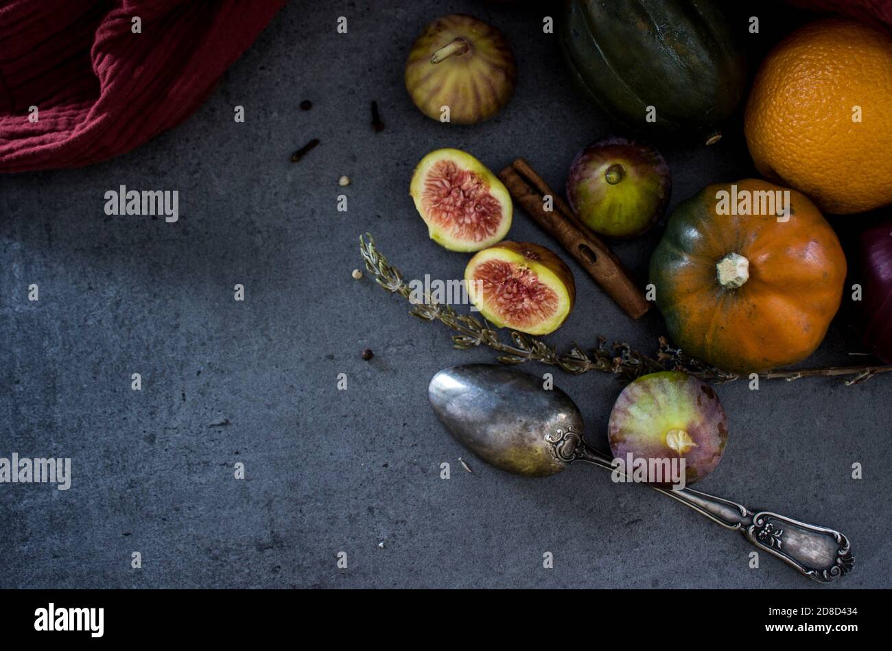 Frutas y verduras frescas en una mesa. Gema de calabaza, ciruelas, higos y cuchara de plata sobre fondo gris. Foto superior de la cosecha de otoño. Foto de stock