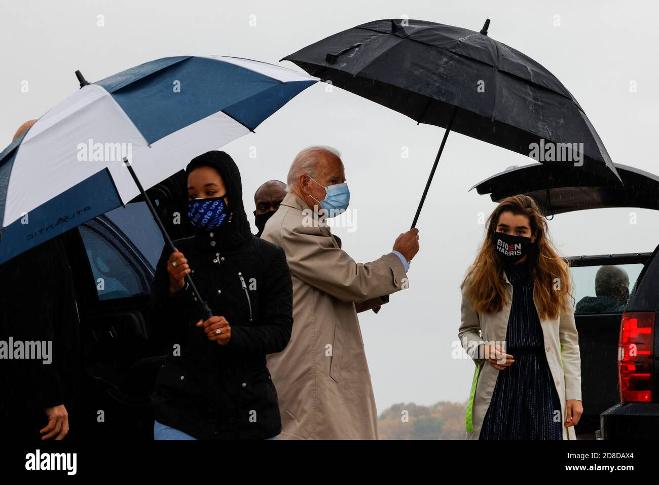 El candidato presidencial demócrata estadounidense y el ex vicepresidente  Joe Biden tiene un paraguas junto a su nieta Natalie mientras se va de  viaje de campaña a Florida en el aeropuerto de