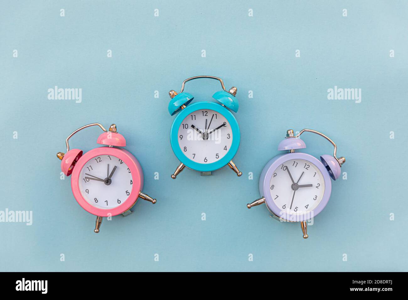 Simplemente diseño minimalista tres timbre doble reloj despertador clásico  aislado sobre fondo azul pastel. Horas de descanso tiempo de vida buena  mañana noche despertar concepto de despertar. Espacio de copia de la