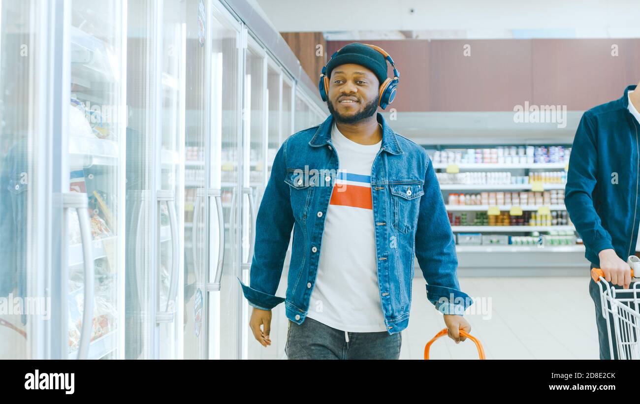 En el supermercado: El elegante chico afroamericano con auriculares camina  por la sección de productos congelados de la tienda Fotografía de stock -  Alamy