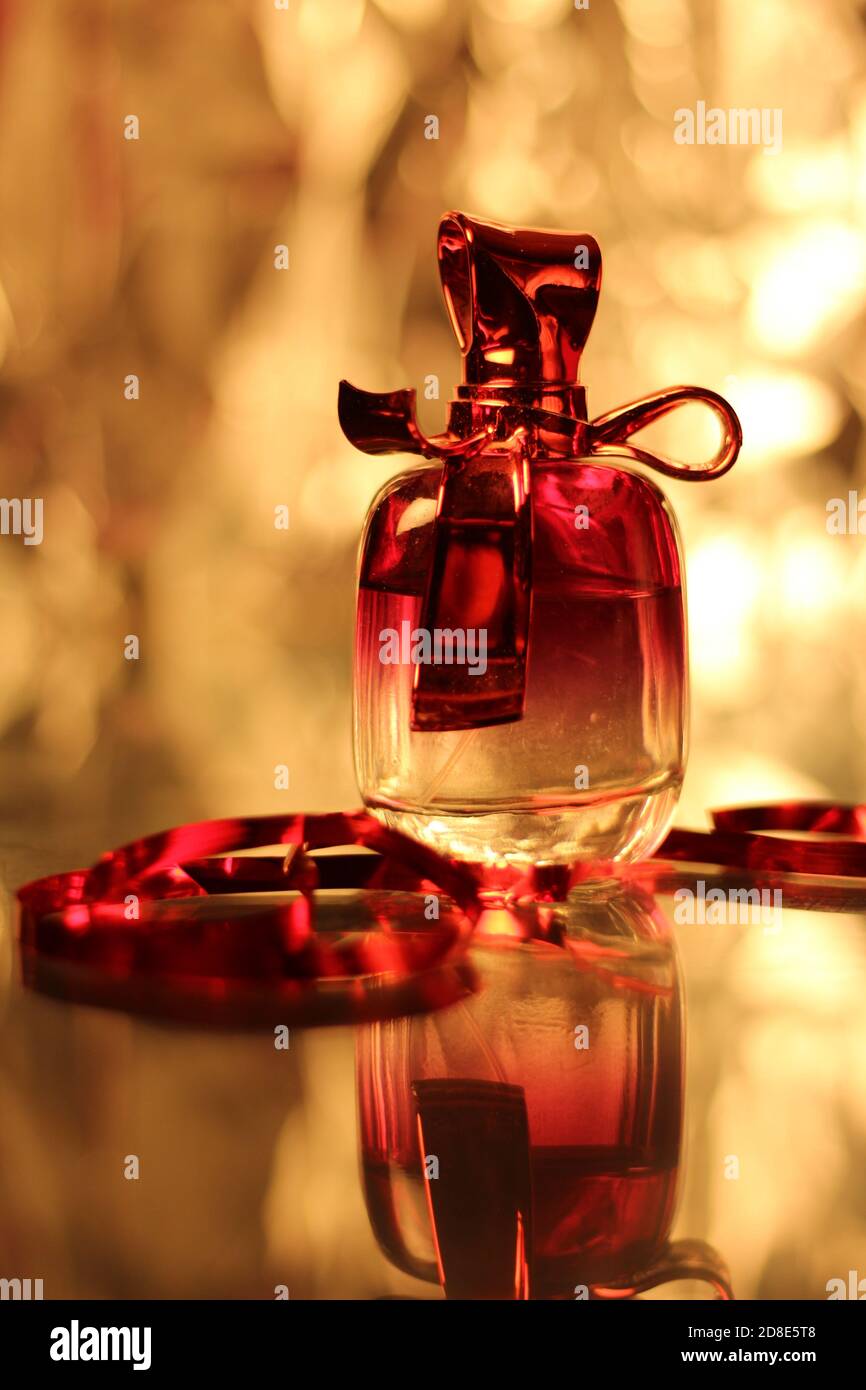 una botella de perfume y una cinta roja Fotografía de stock - Alamy