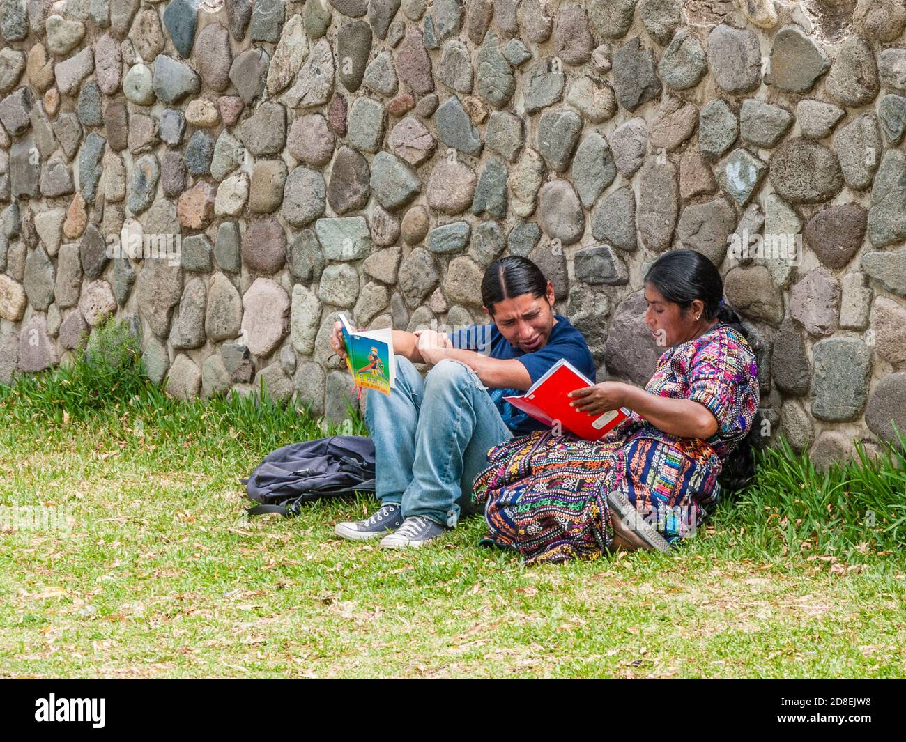 Pareja guatemalteca leyendo en hierba Foto de stock