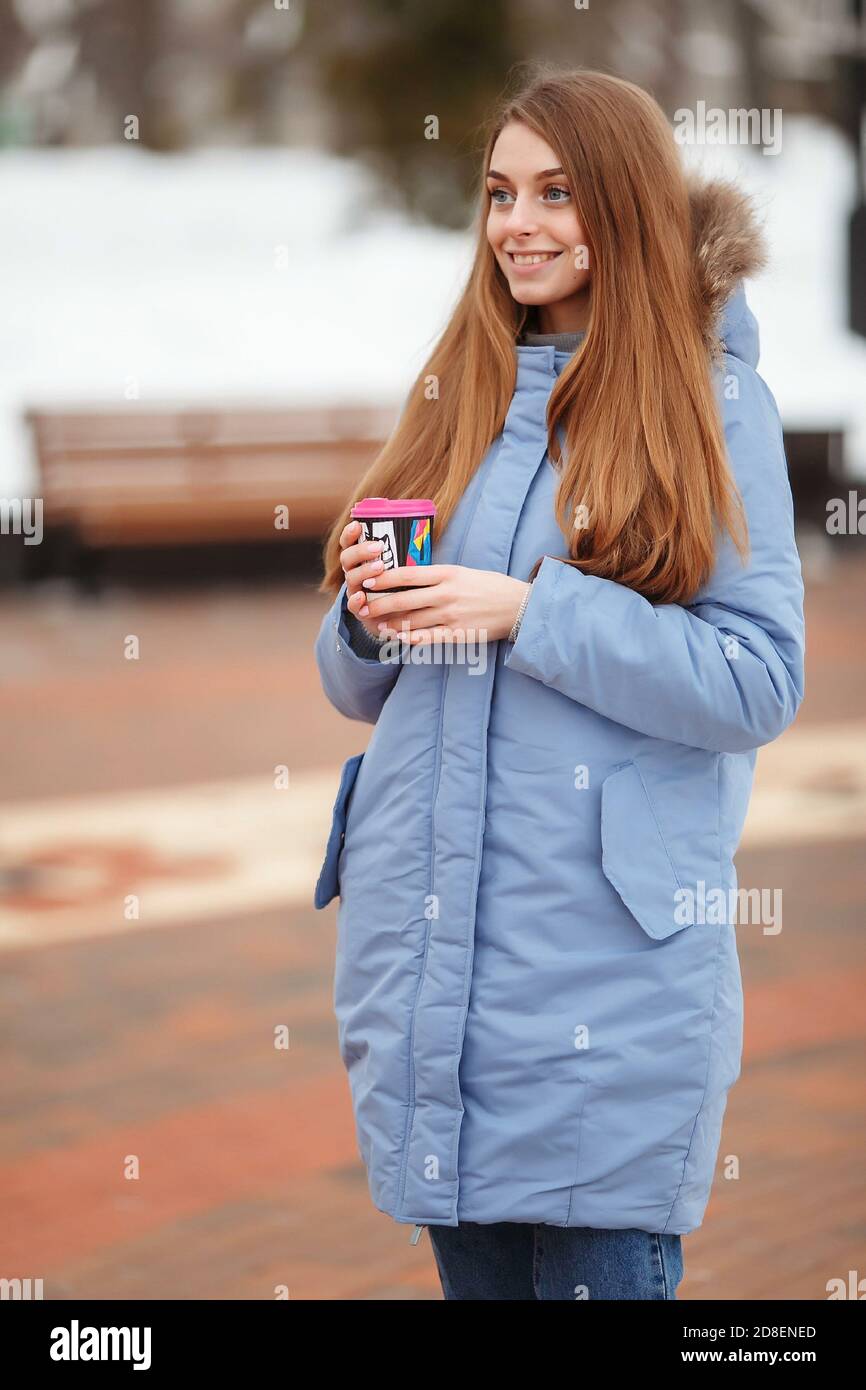 Mujer joven con ropa de abrigo en el frío invierno nieve bebiendo café para  llevar