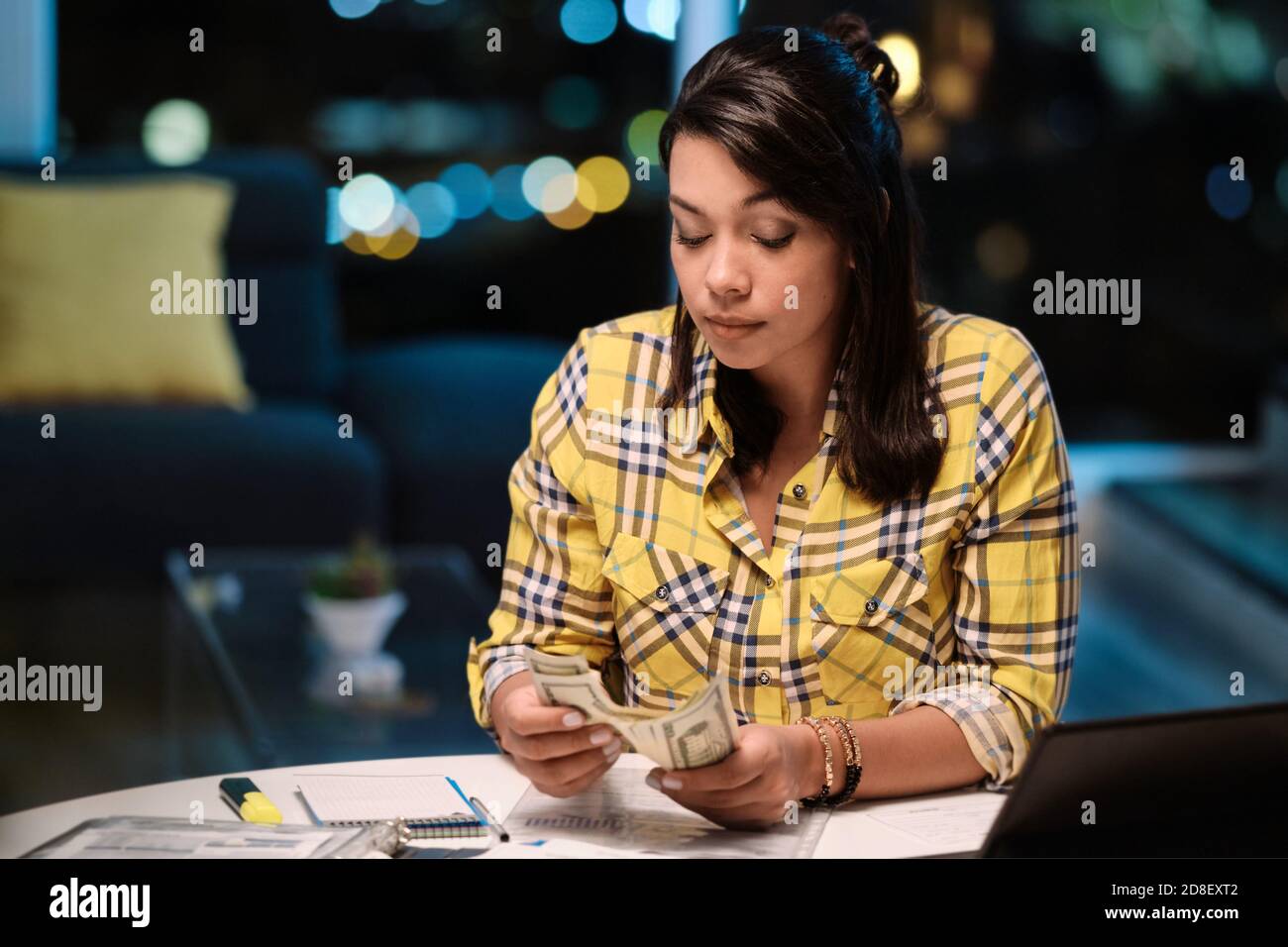 Mujer Latinoamericana haciendo el Presupuesto de Casa y dinero contante Foto de stock