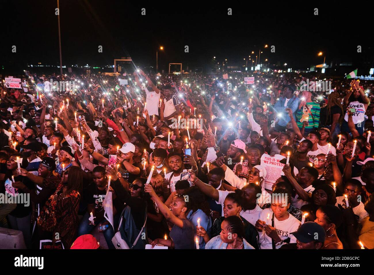 Los manifestantes protestan a la luz de las velas por víctimas de la brutalidad policial durante las protestas etiquetadas con #EndSRAS en el peaje de Lekki en Lagos, Nigeria, el 16 de octubre de 2020 Foto de stock