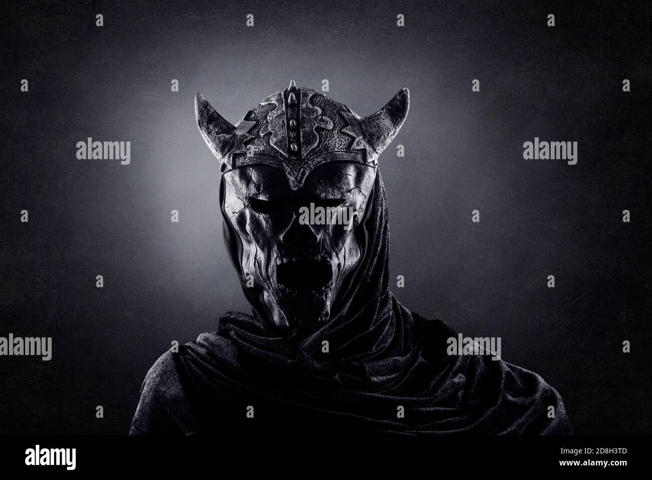Demonio con casco de cuernos en la oscuridad Fotografía de stock - Alamy