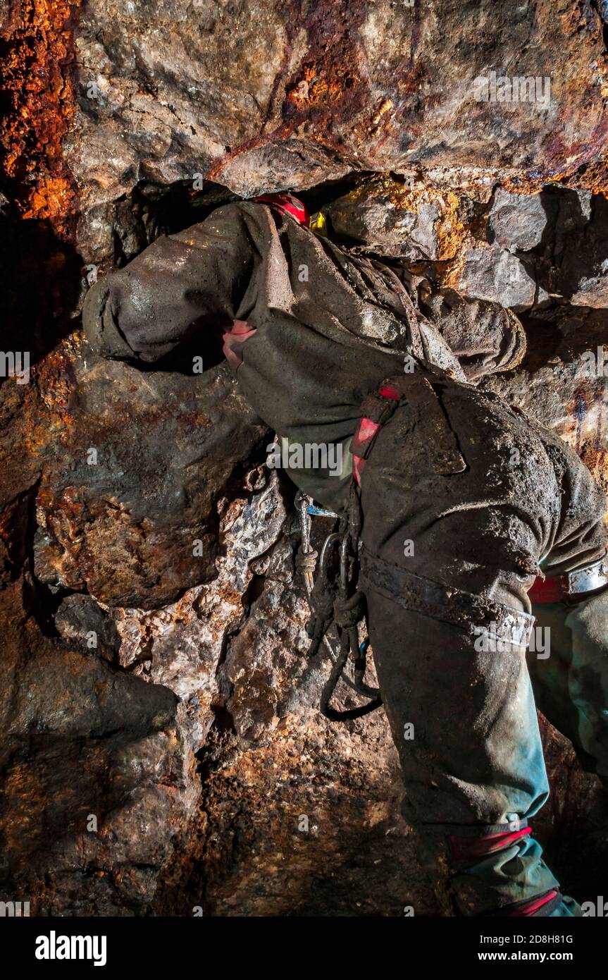 Mirando a través de una pequeña ventana de ventilación o "thurl" entre dos venas minerales estrechamente paralelas en Odin Mine, Castleton, Derbyshire. Foto de stock
