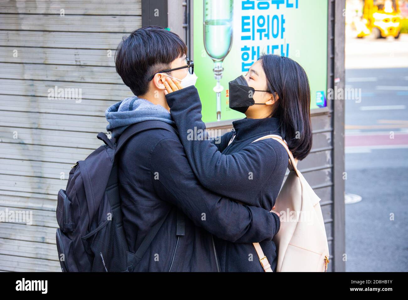 Pareja joven que lleva máscaras durante la pandemia de Coronavirus, Seúl, Corea del Sur Foto de stock