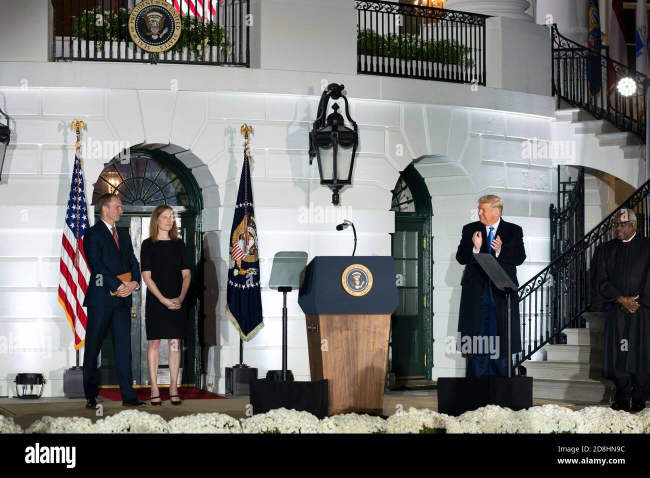 El presidente estadounidense Donald Trump aplaude a la juez asociada de la Corte Suprema Amy Coney Barrett y a su esposo Jesse Barrett durante la ceremonia de juramento en el South Lawn de la Casa Blanca el 26 de octubre de 2020 en Washington, DC. Foto de stock