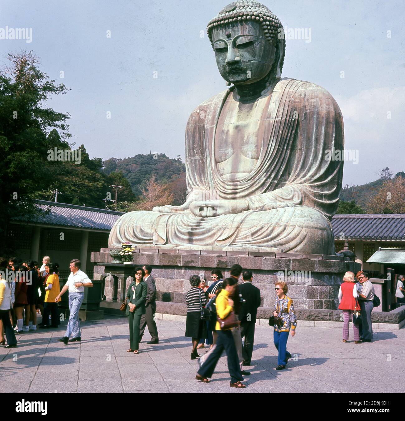 1960, histórico, visitantes en el templo budista en Kotoku-in, Kamakura, Kanagawa, Japón, hogar del Daibutsu o Gran Buda, una estatua gigante de bronce y una de las atracciones turísticas más visitadas del país. La estatua data del siglo 13 y es el segundo Buda de bronce más alto de Japón. Foto de stock