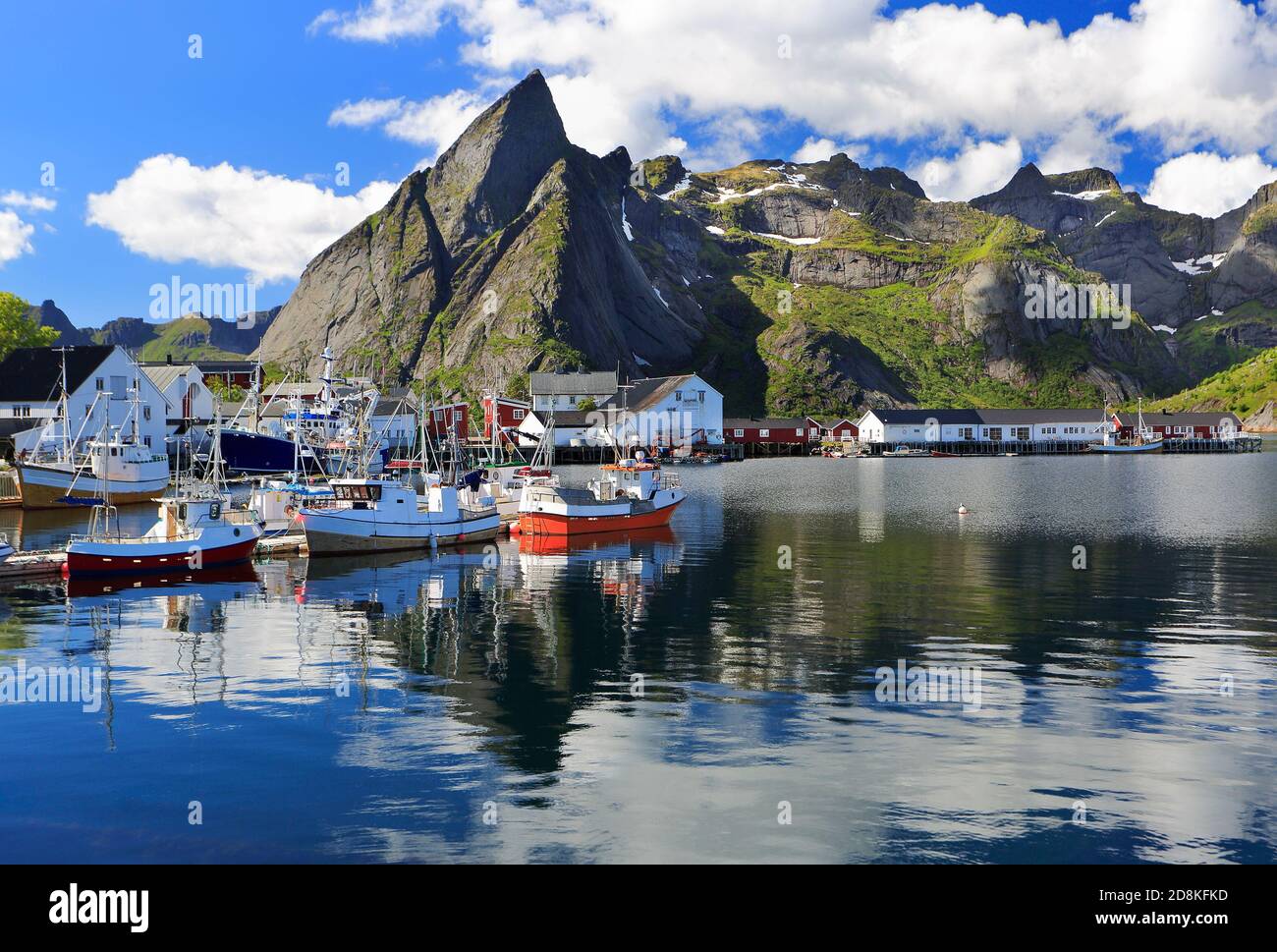 Montañas y barcos de pesca que se reflejan en el fiordo de Hamnoy, Islas Lofoten, Noruega Foto de stock