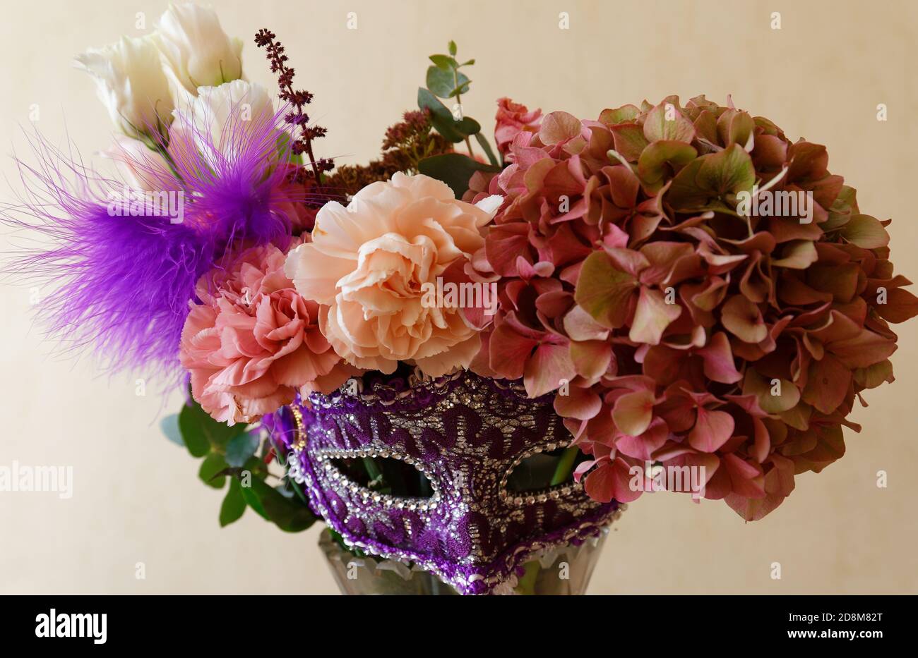 El hermoso ramo de flores con máscara fija de carnaval sobre fondo llano  Fotografía de stock - Alamy